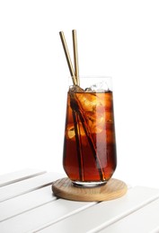 Glass of tasty refreshing drink and straws on wooden table against white background