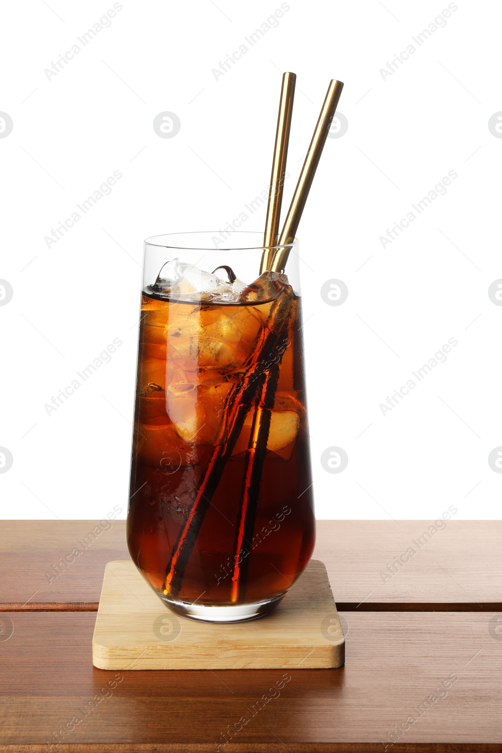 Photo of Glass of tasty refreshing drink and straws on wooden table against white background