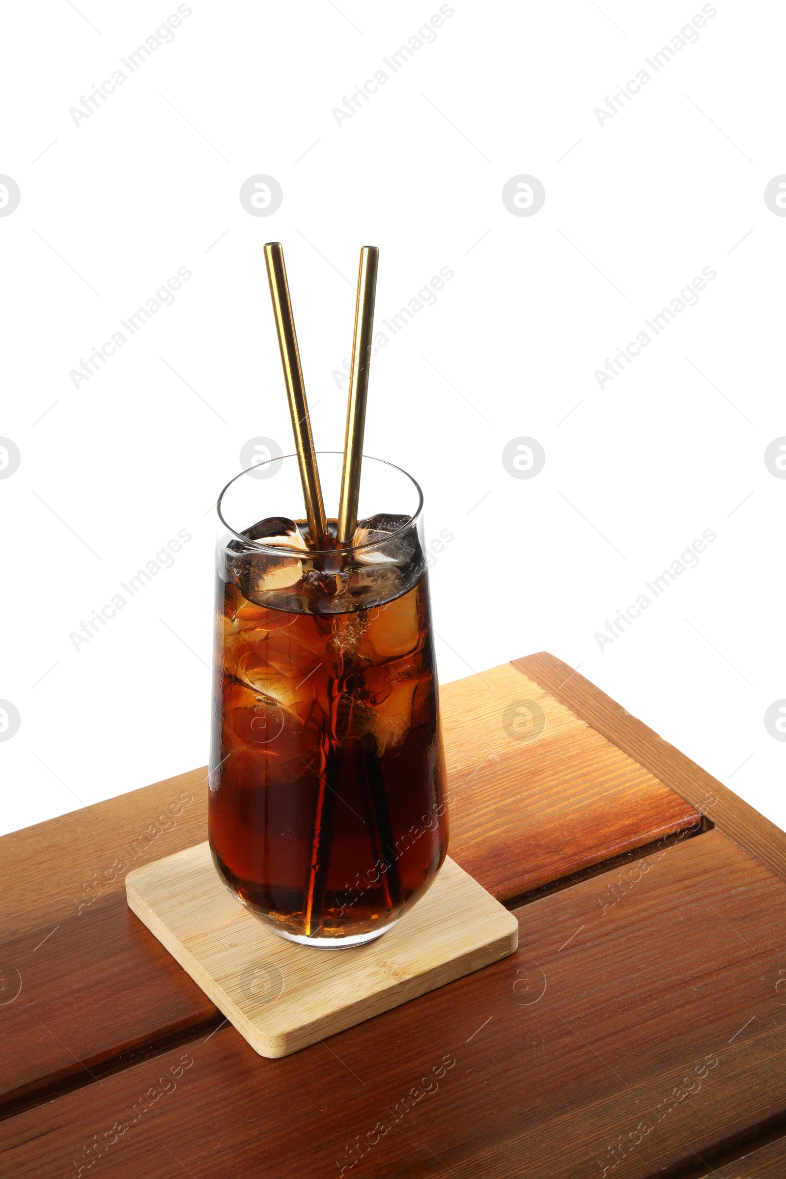 Photo of Glass of tasty refreshing drink and straws on wooden table against white background