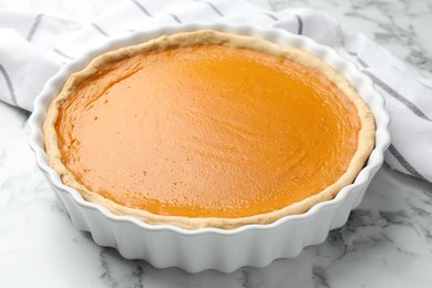 Tasty homemade pumpkin pie on white marble table, closeup