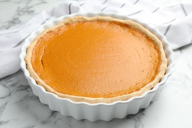 Photo of Tasty homemade pumpkin pie on white marble table, closeup