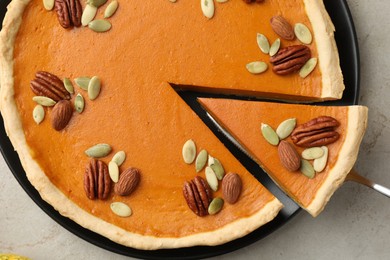 Photo of Taking piece of tasty homemade pumpkin pie at grey table, top view