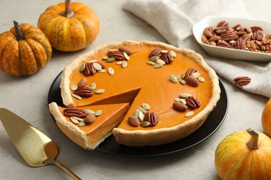 Photo of Tasty homemade pumpkin pie served on grey table