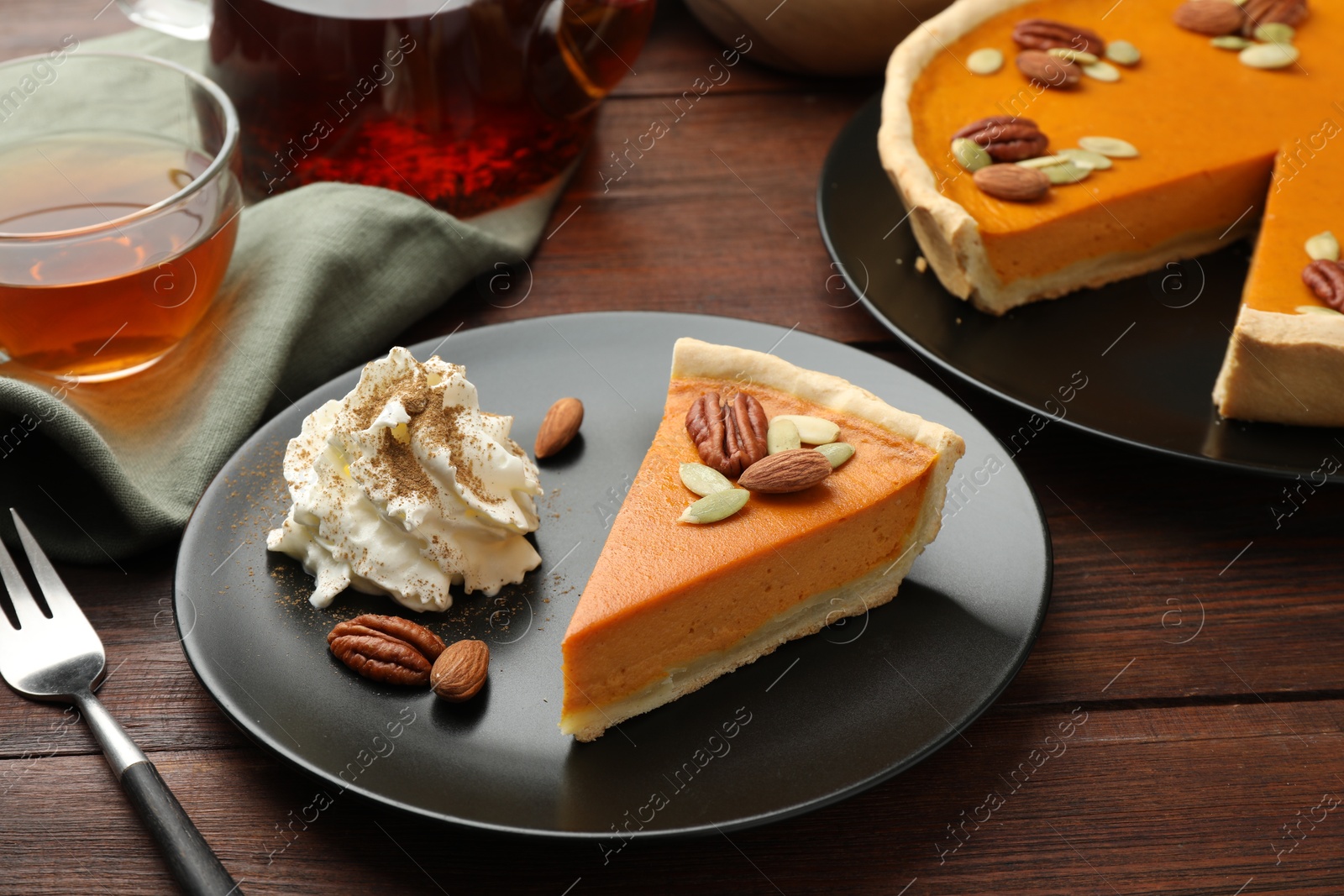 Photo of Piece of tasty homemade pumpkin pie served on wooden table, closeup