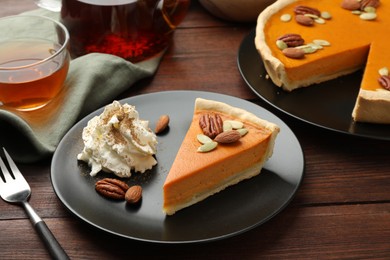 Piece of tasty homemade pumpkin pie served on wooden table, closeup