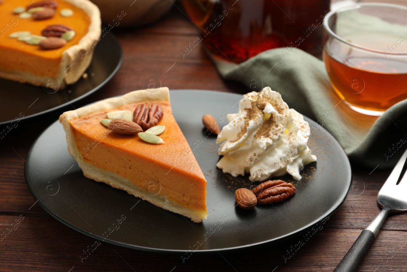 Photo of Piece of tasty homemade pumpkin pie served on wooden table, closeup