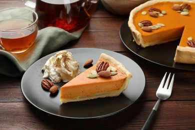 Piece of tasty homemade pumpkin pie served on wooden table