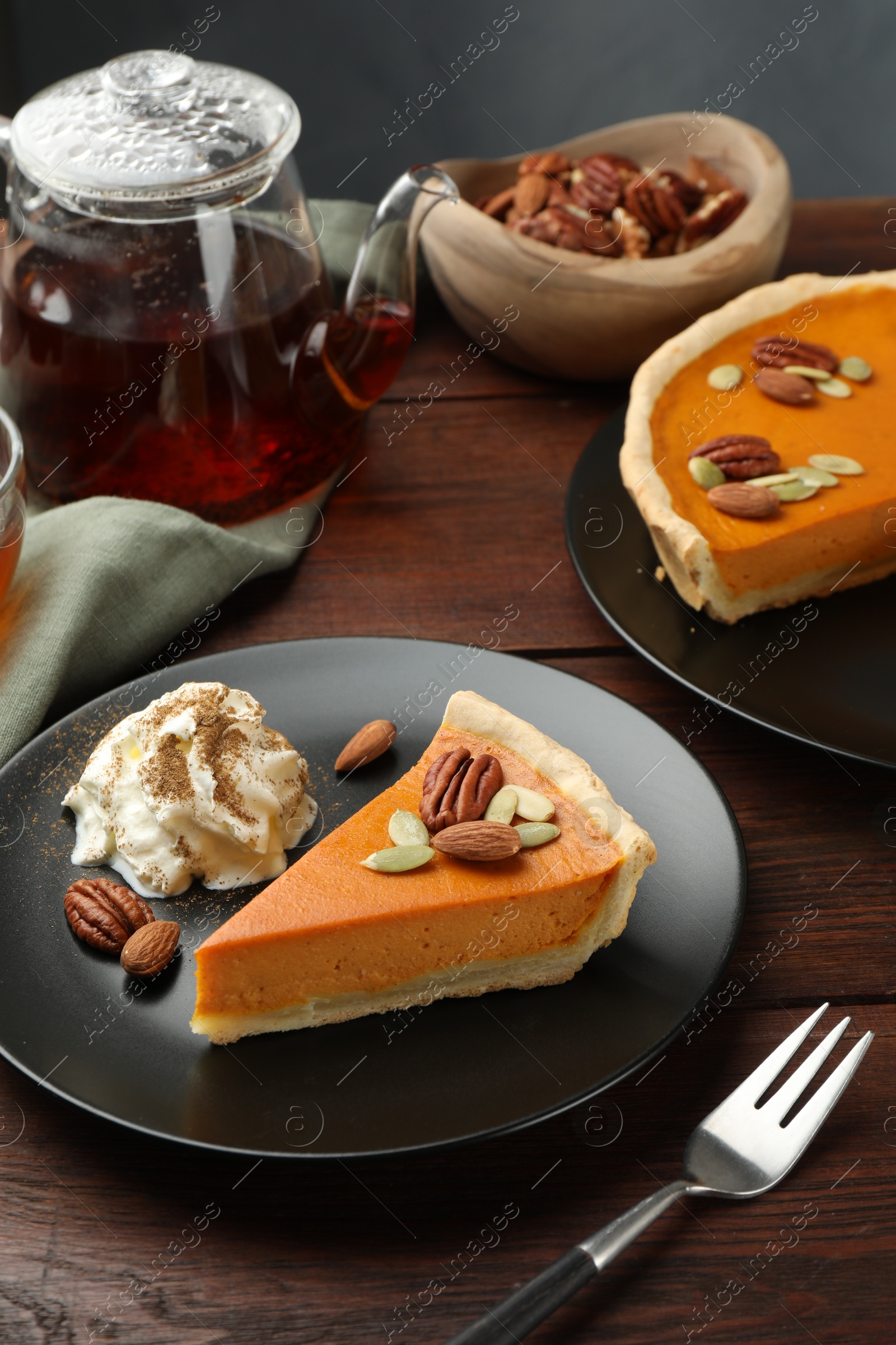 Photo of Piece of tasty homemade pumpkin pie served on wooden table