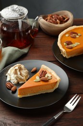 Photo of Piece of tasty homemade pumpkin pie served on wooden table