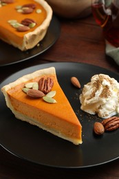 Photo of Piece of tasty homemade pumpkin pie served on wooden table, closeup