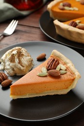 Piece of tasty homemade pumpkin pie served on wooden table, closeup