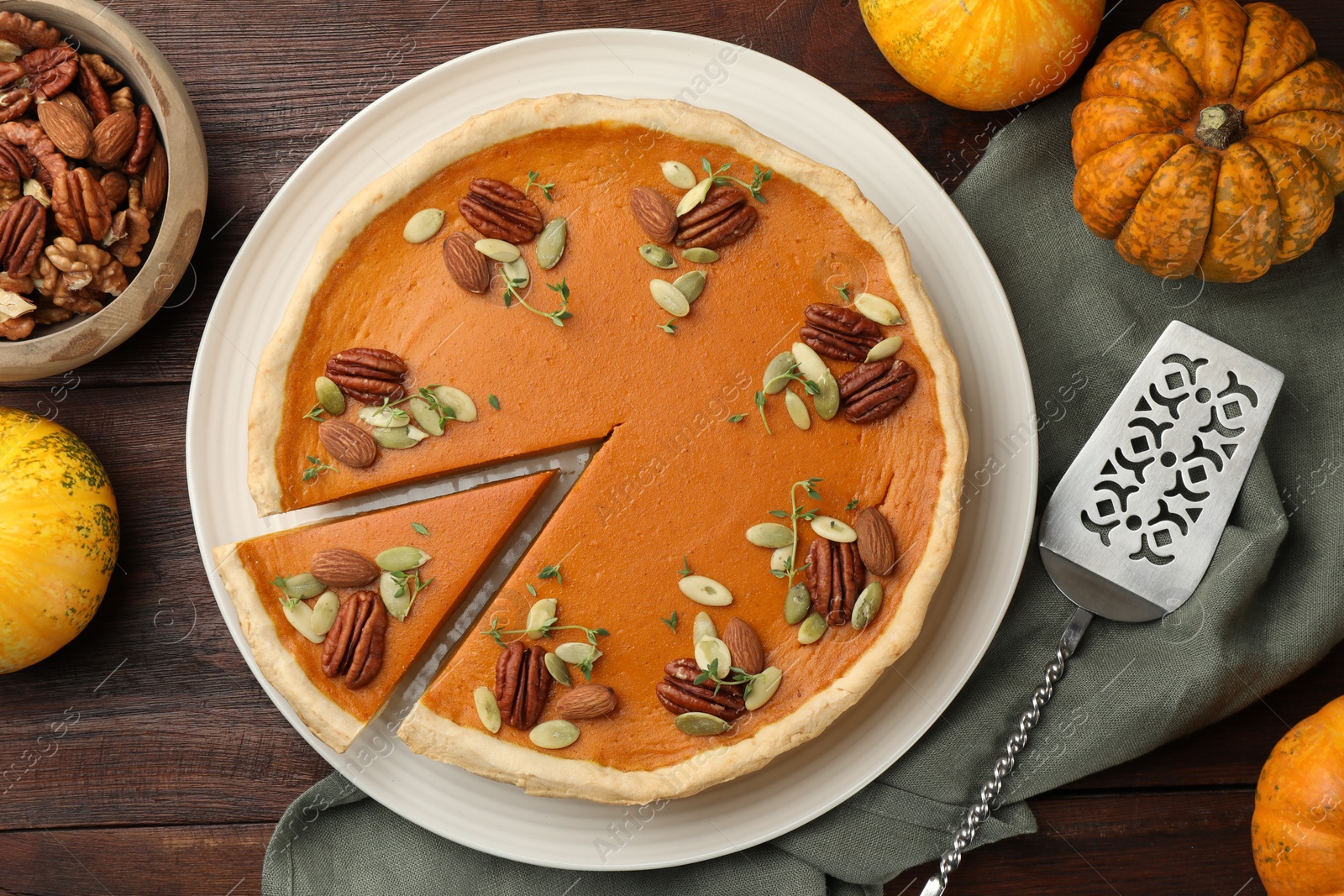 Photo of Tasty homemade pumpkin pie served on wooden table, top view