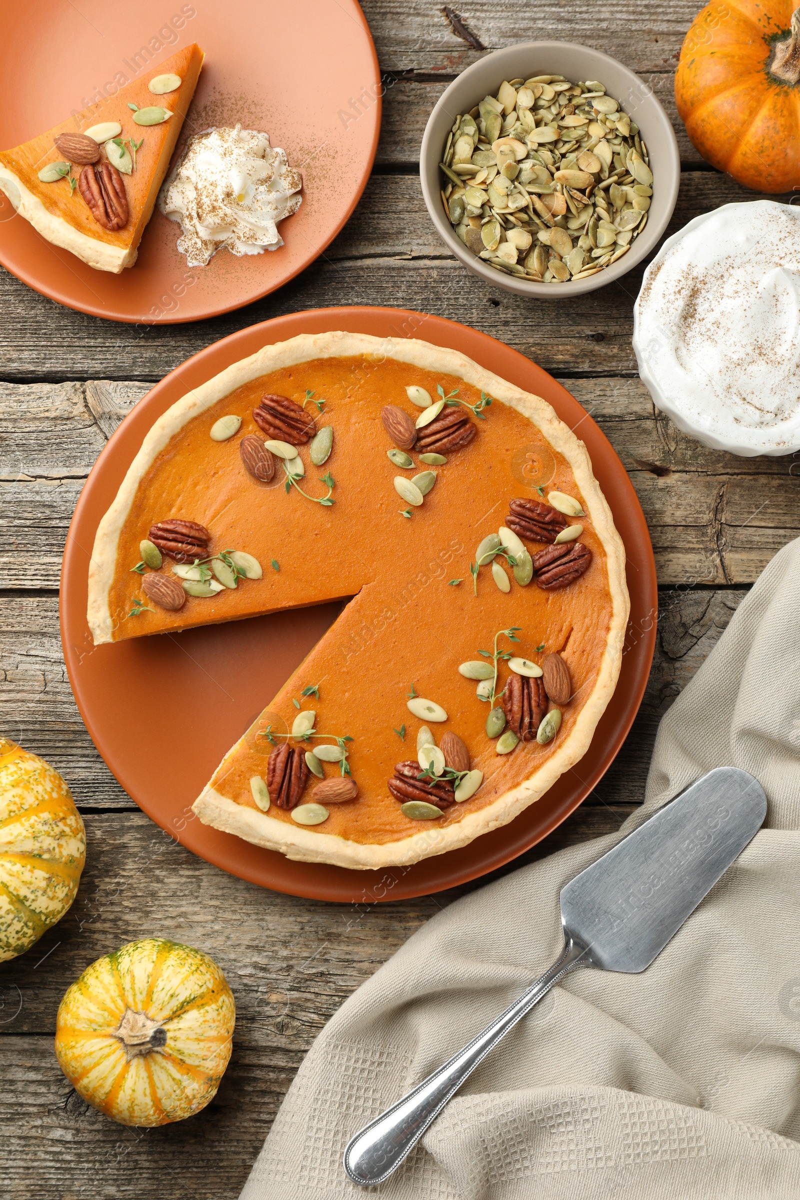 Photo of Tasty homemade pumpkin pie served on wooden table, top view