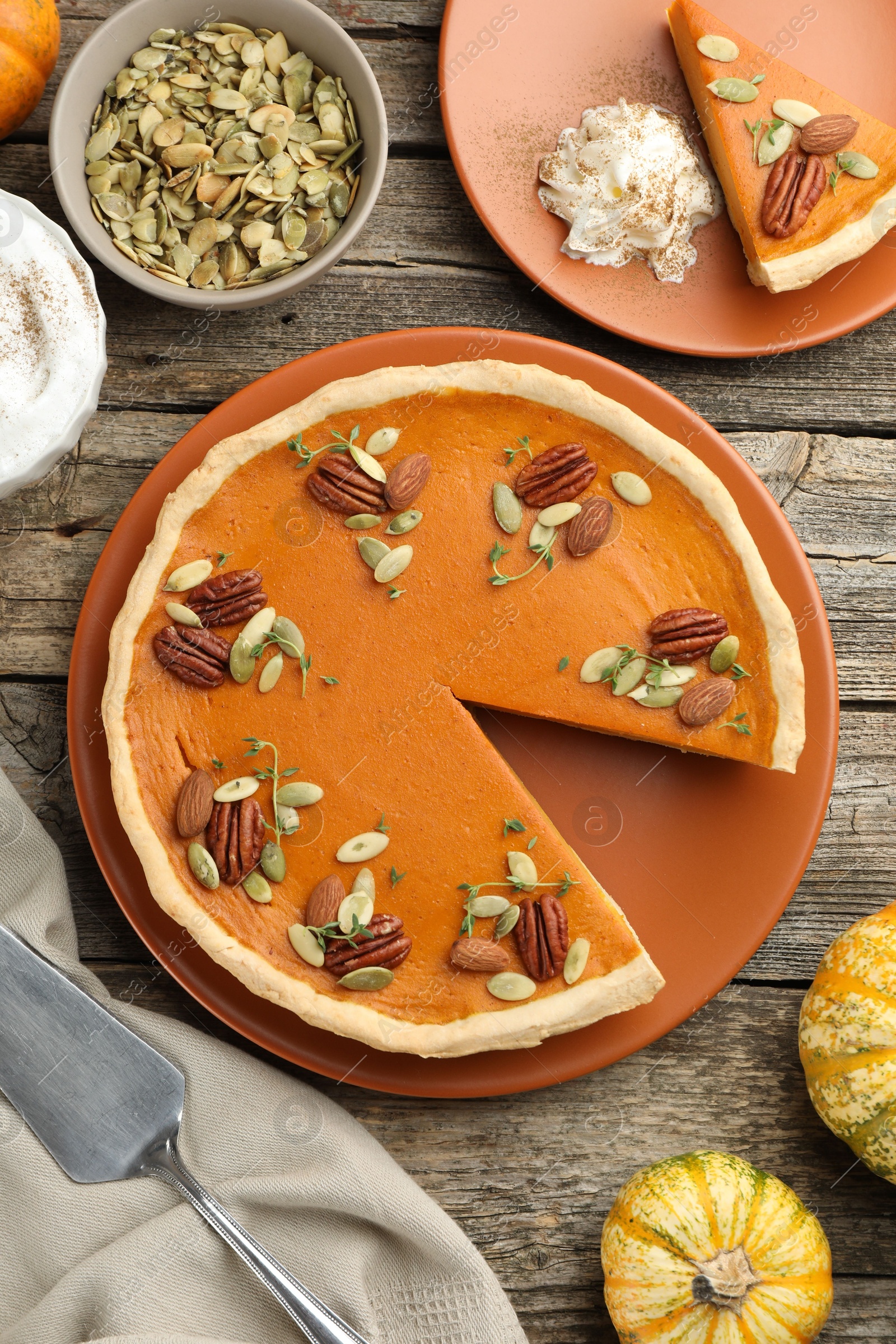 Photo of Tasty homemade pumpkin pie served on wooden table, top view