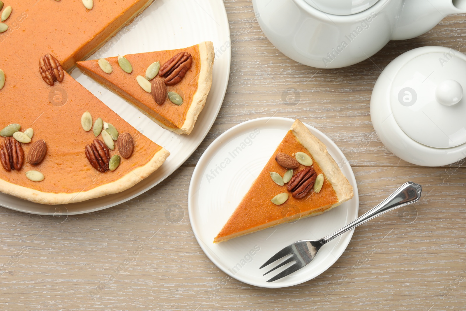 Photo of Tasty homemade pumpkin pie served on wooden table, top view