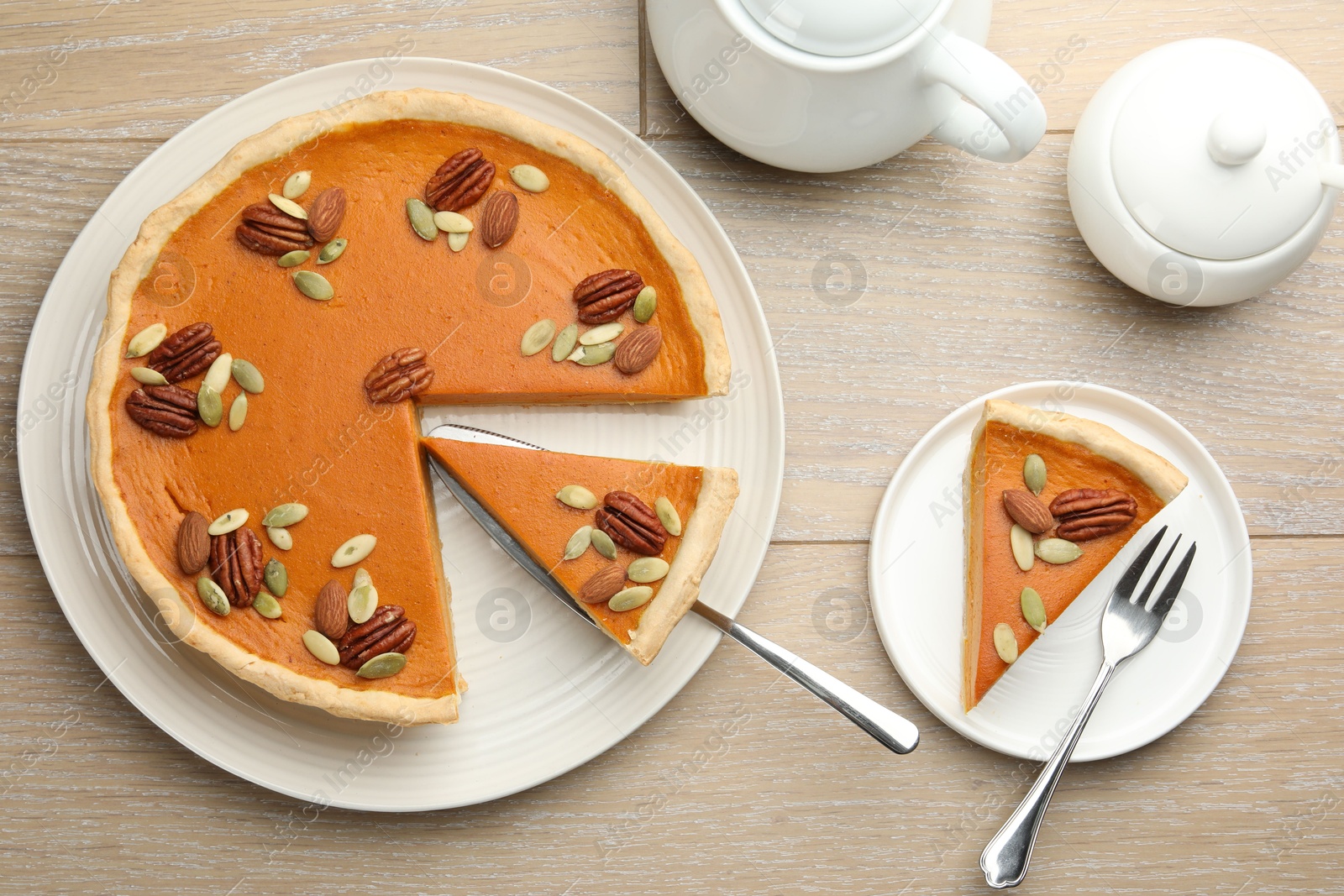 Photo of Tasty homemade pumpkin pie served on wooden table, top view