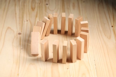 Photo of Domino effect. Blocks falling on wooden table