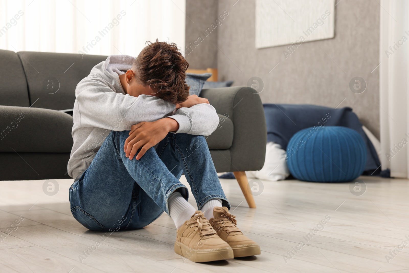 Photo of Loneliness concept. Sad teenage boy on floor at home