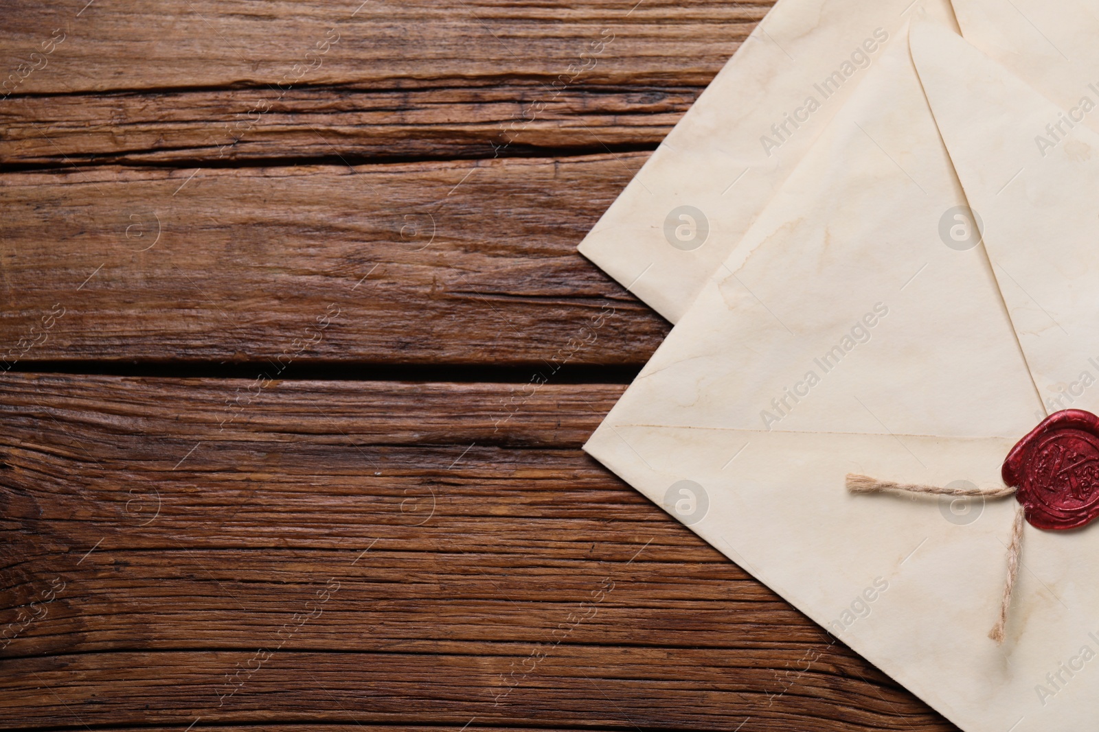 Photo of Old letter envelopes on wooden table, top view. Space for text