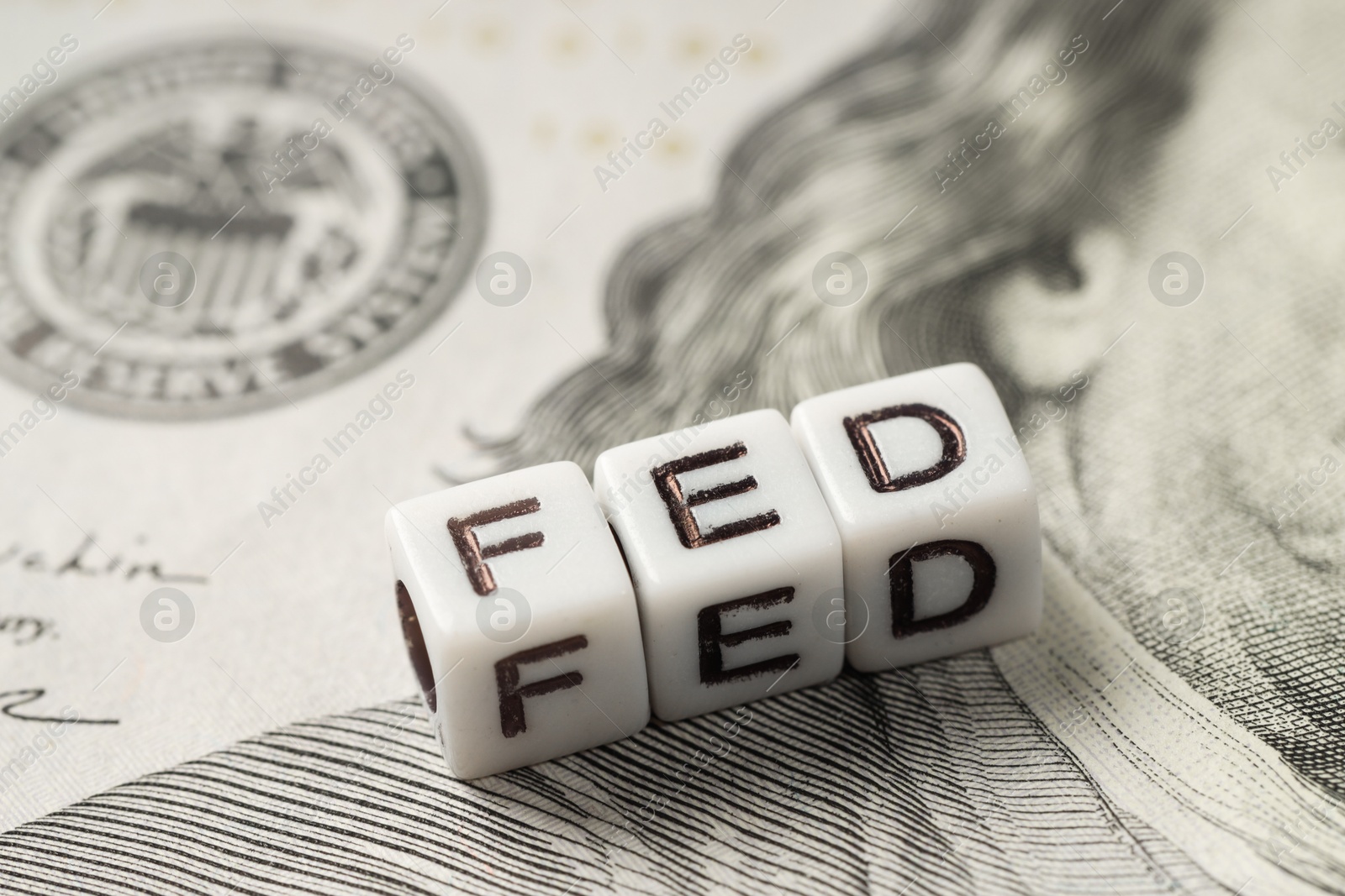 Photo of Cubes with letters Fed (Federal Reserve System) on dollar banknote, closeup