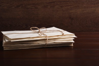 Photo of Stack of old letters tied with twine on wooden table