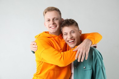 Portrait of two happy brothers on light background