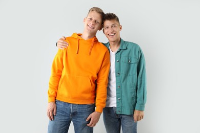 Photo of Portrait of two happy brothers on light background