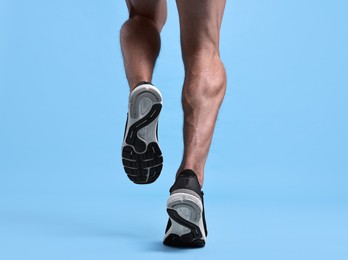 Photo of Man running on light blue background, closeup