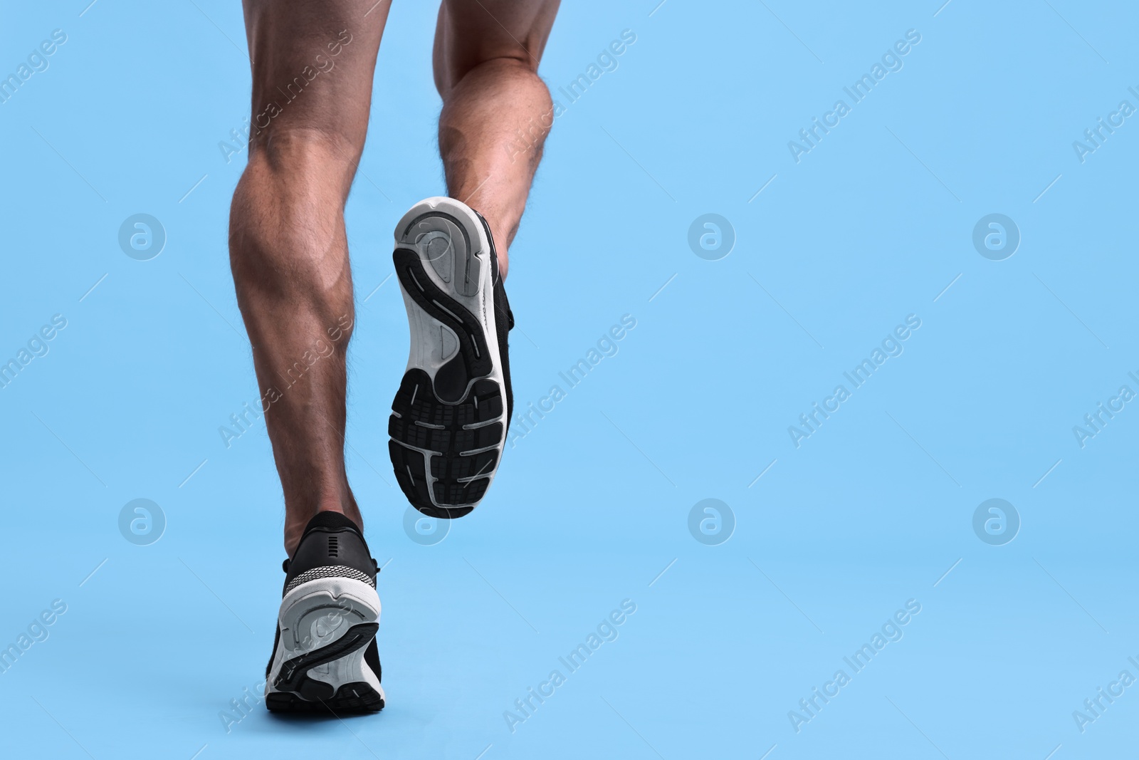 Photo of Man running on light blue background, closeup