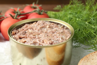 Canned meat in tin can on table, closeup