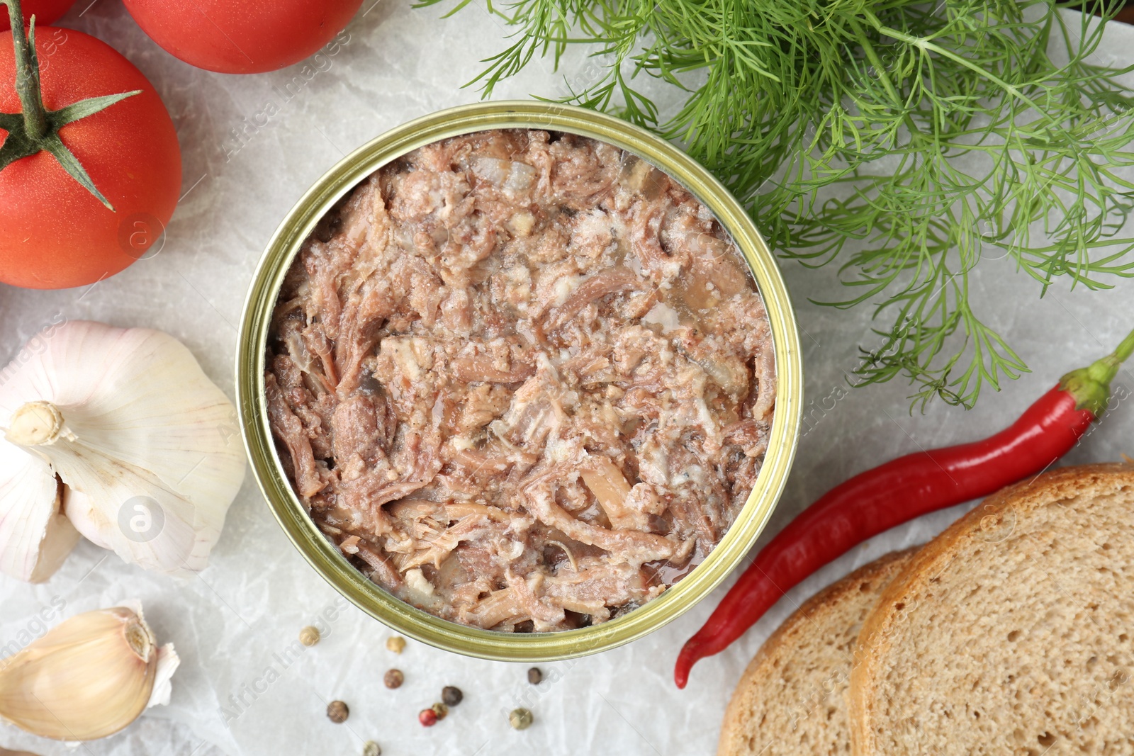 Photo of Canned meat in tin can served on table, flat lay