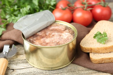 Canned meat in tin can served on wooden table, closeup