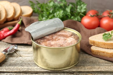 Photo of Canned meat in tin can served on wooden table, closeup