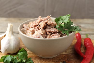 Photo of Canned meat in bowl and fresh products on table, closeup