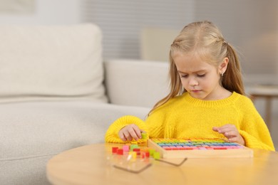 Photo of Little girl playing with math game Times table tray at home. Space for text