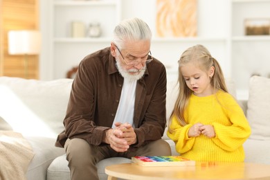 Photo of Grandpa and his granddaughter playing with math game Times table tray at home