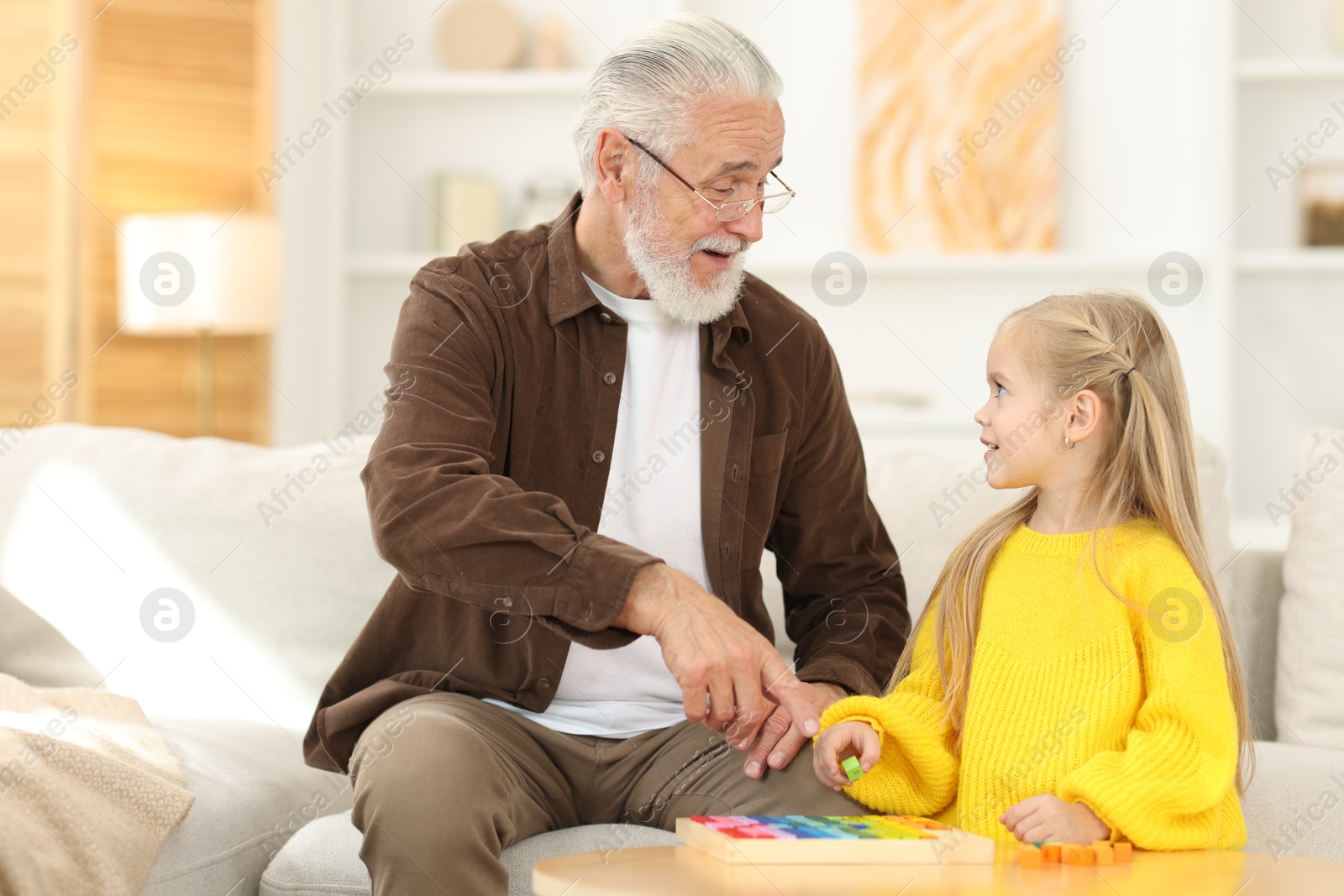 Photo of Grandpa and his granddaughter playing with math game Times table tray at home