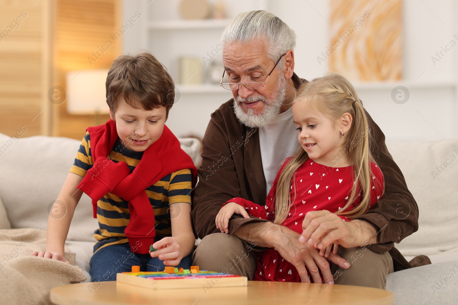 Photo of Grandpa and his grandkids playing with math game Times table tray at home