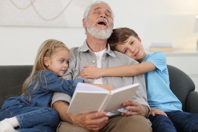 Photo of Grandpa and his grandkids on sofa at home