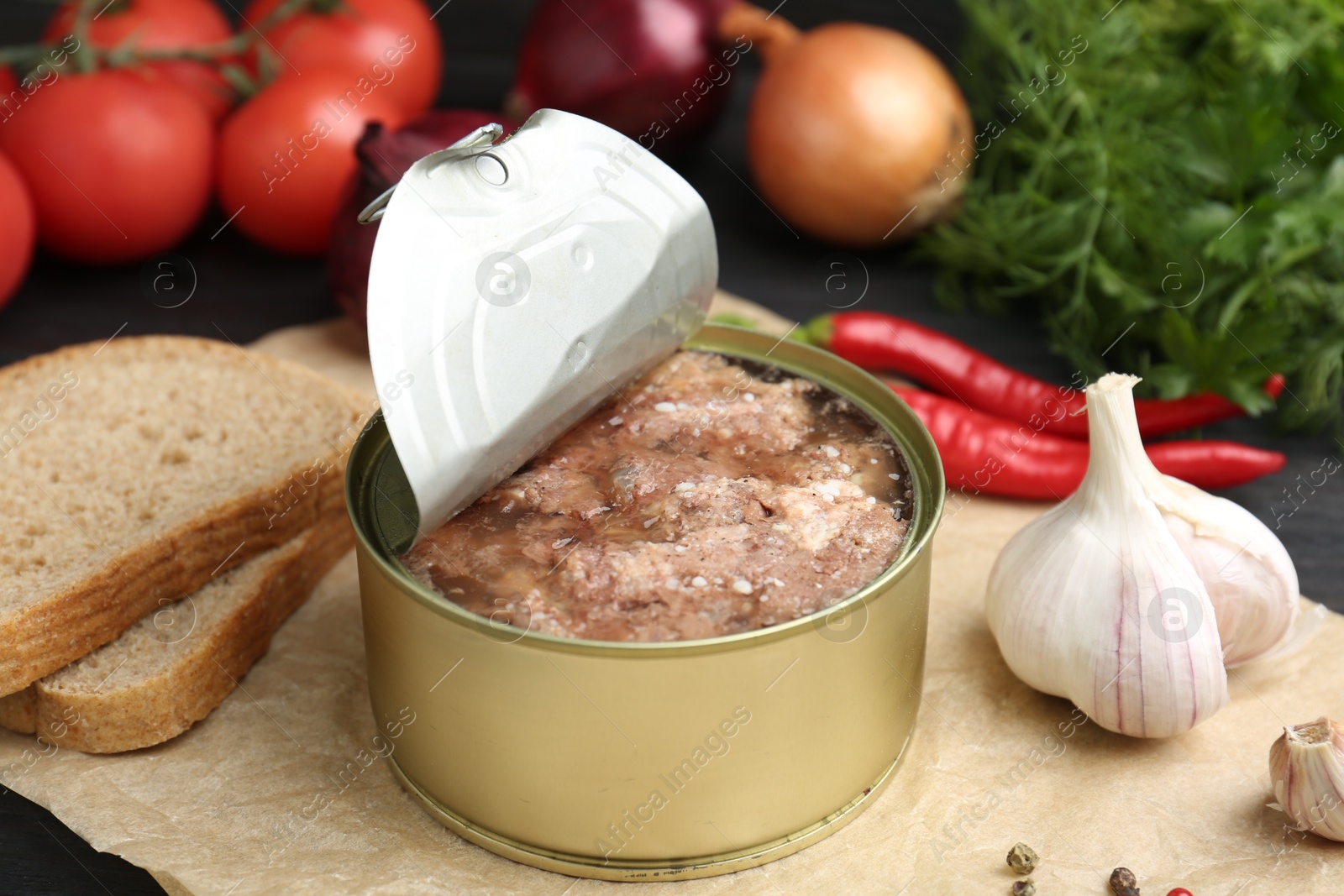 Photo of Canned meat in tin can and other products on table, closeup