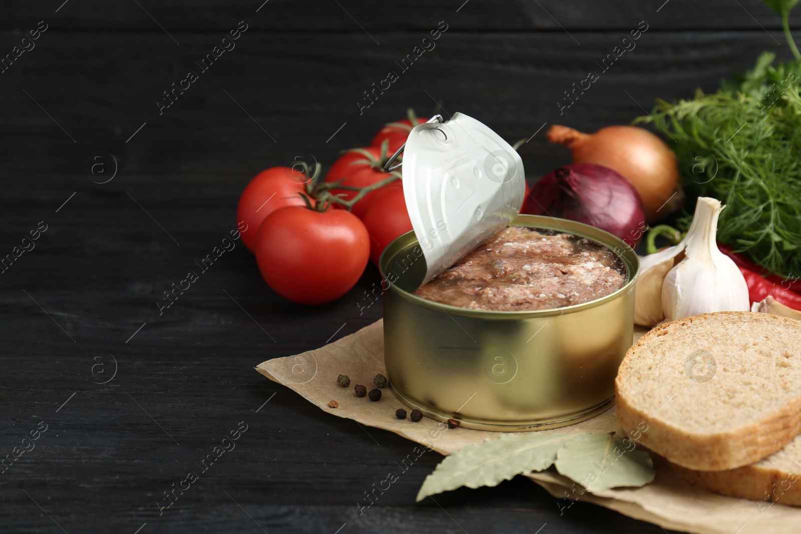 Photo of Canned meat in tin can and other products on wooden table. Space for text