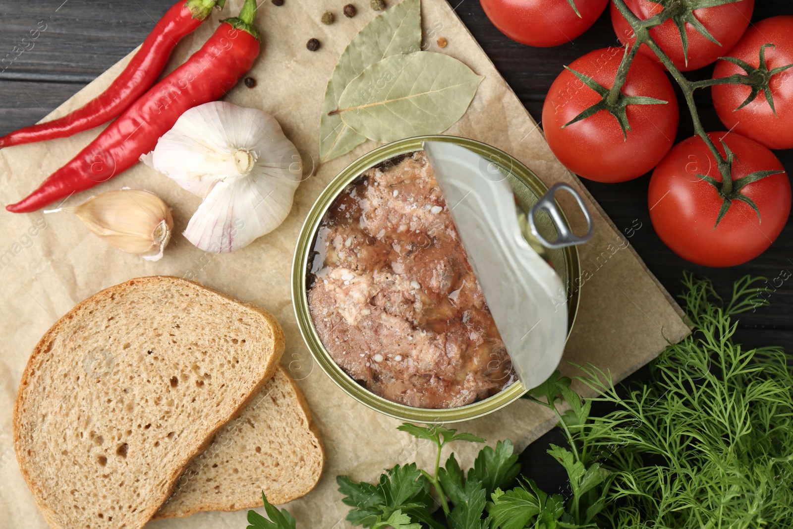 Photo of Canned meat in tin can and other products on wooden table, top view