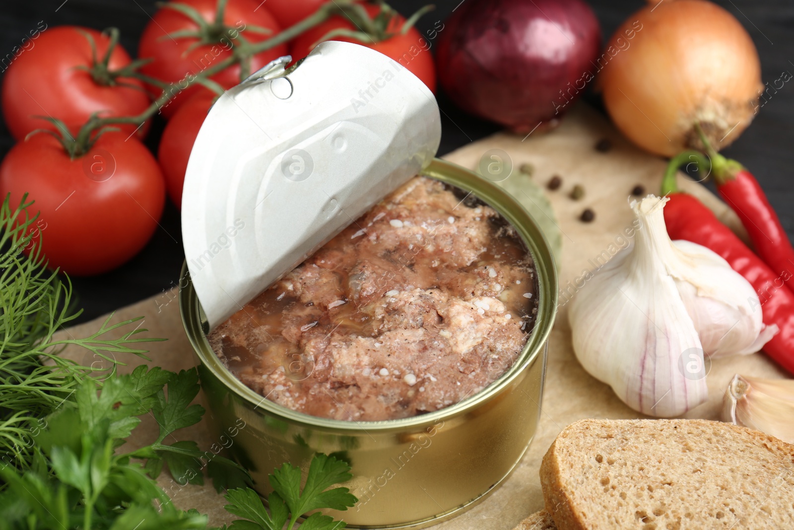 Photo of Canned meat in tin can and other products on table, closeup