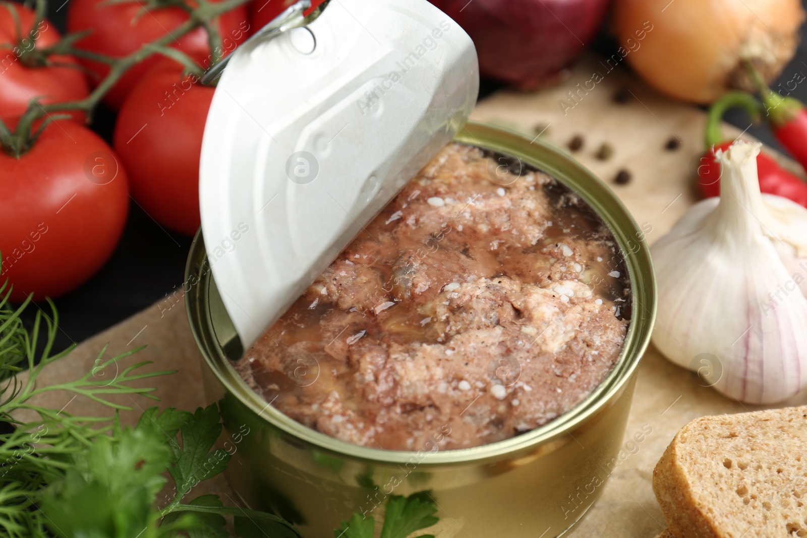 Photo of Canned meat in tin can and other products on table, closeup