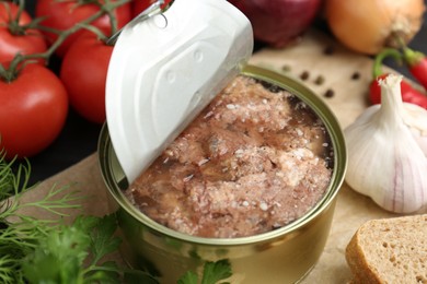 Photo of Canned meat in tin can and other products on table, closeup