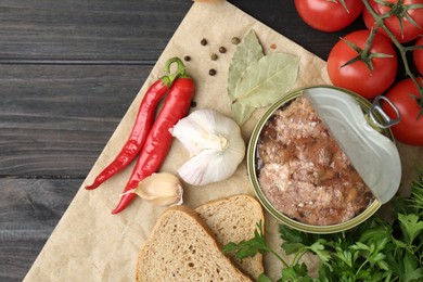 Photo of Canned meat in tin can and other products on wooden table, top view