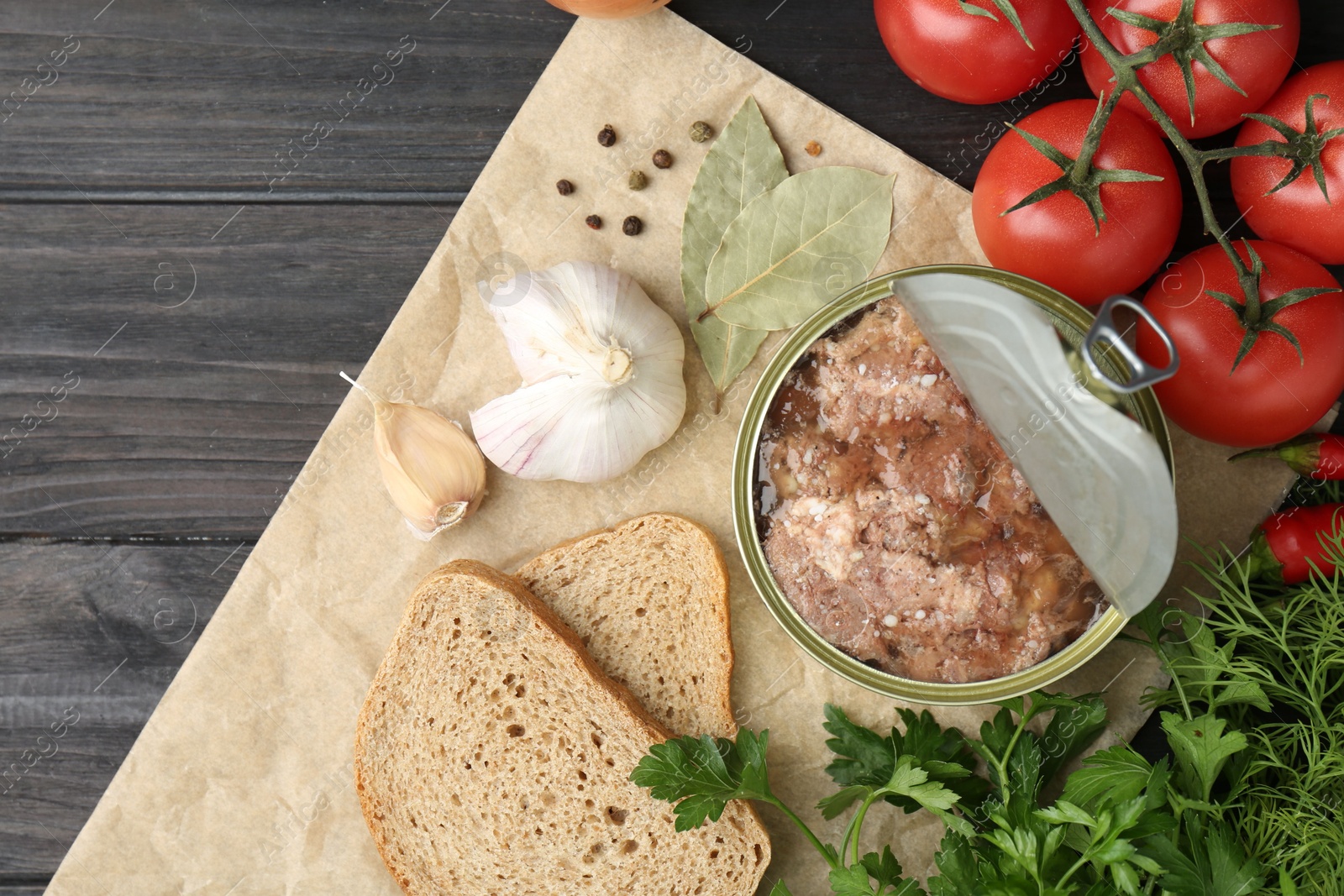 Photo of Canned meat in tin can and other products on wooden table, top view