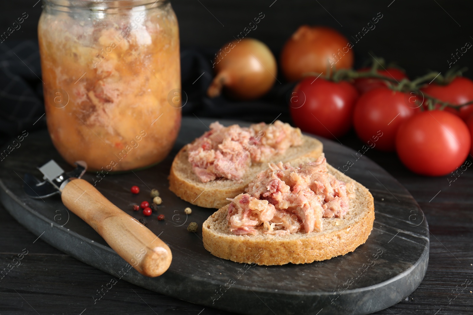 Photo of Sandwiches with canned meat and opener on wooden table, closeup