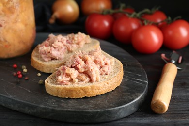 Photo of Sandwiches with canned meat and opener on wooden table, closeup