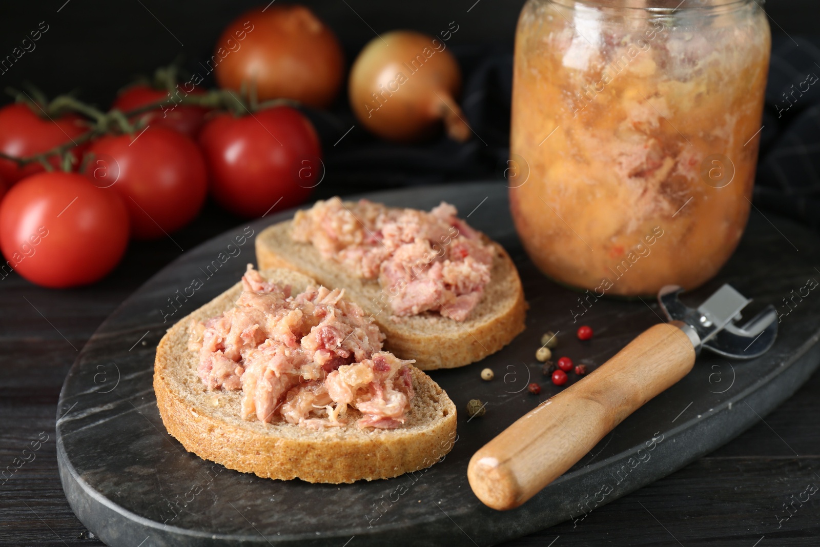 Photo of Sandwiches with canned meat and opener on wooden table, closeup